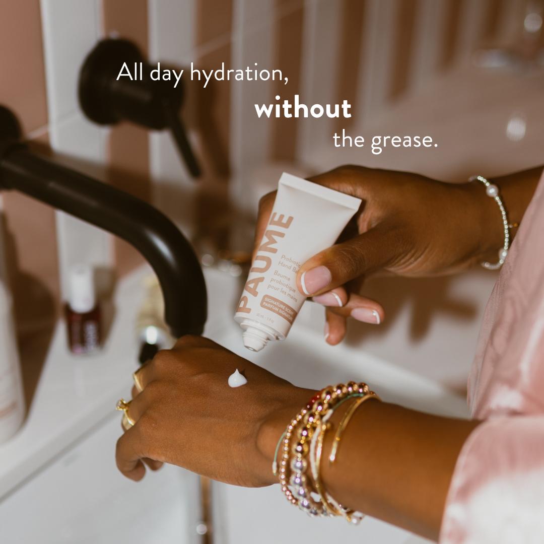 Hand applying anti-aging cream from a tube labeled 'PAUME' with text 'All day hydration, without the grease.'